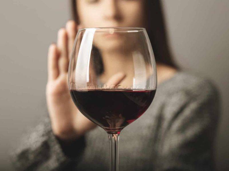 reject liquor, stop alcohol, teenager girl shows a sign of refusal of wine