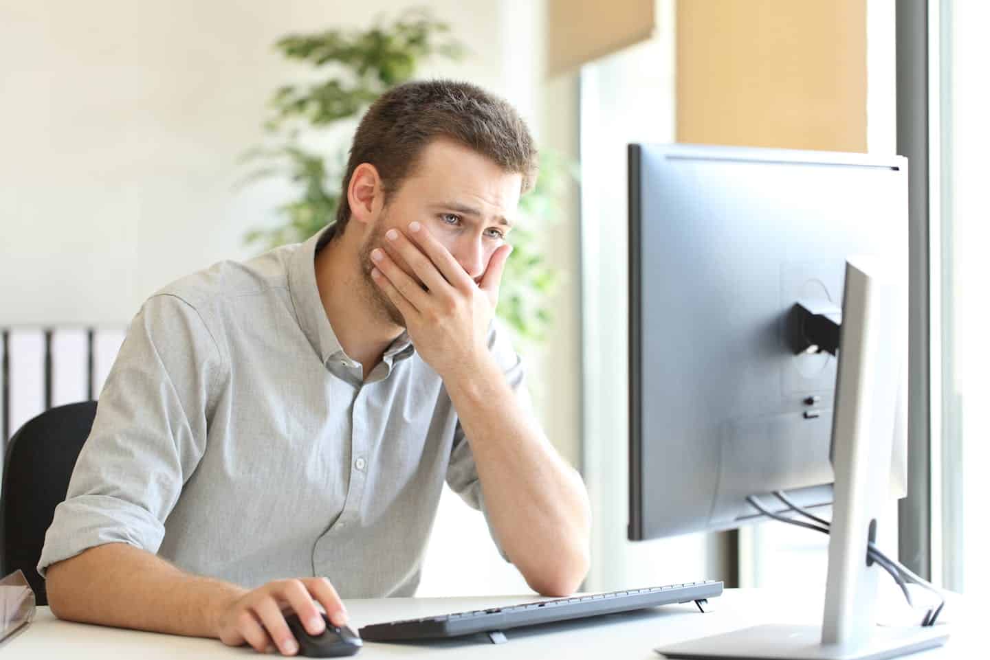 Man focused on working at a computer in a home office setting