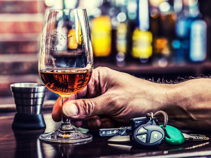 Alcoholism. Cup cognac hand man the keys to the car and irresponsible driver.