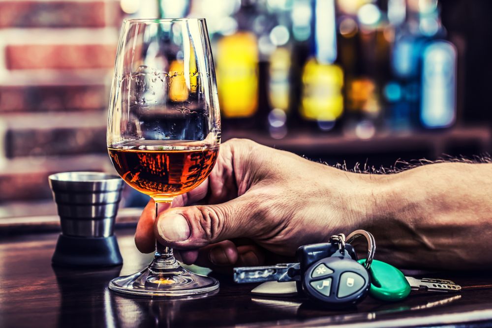 Alcoholism. Cup cognac hand man the keys to the car and irresponsible driver.