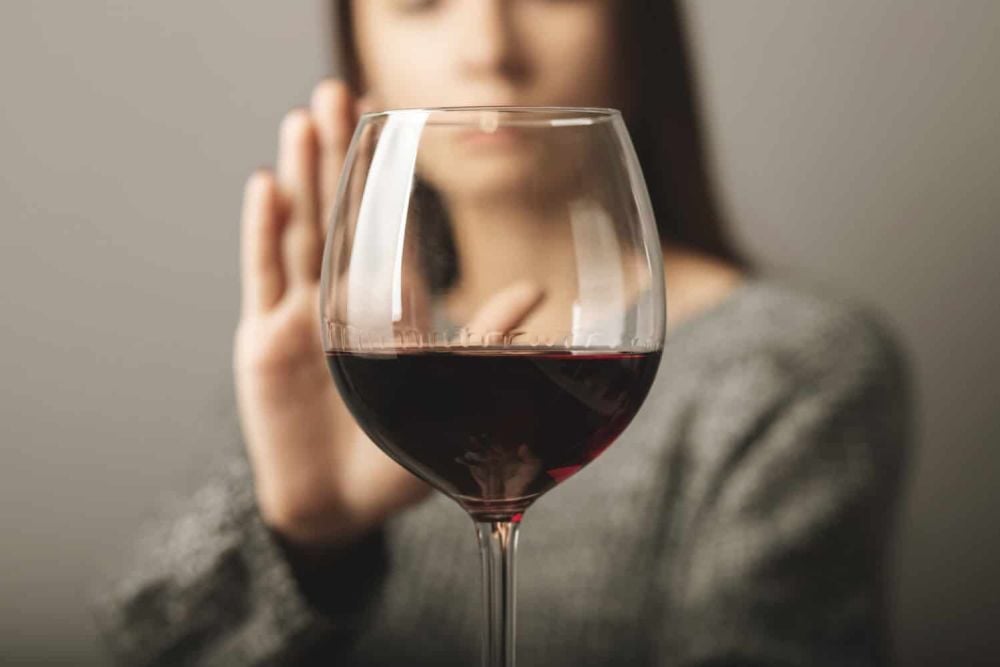reject liquor, stop alcohol, teenager girl shows a sign of refusal of wine