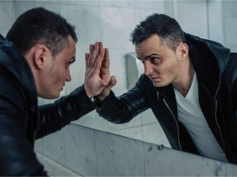 image of man looking at himself in the mirror representing the struggle of someone with substance abuse issues