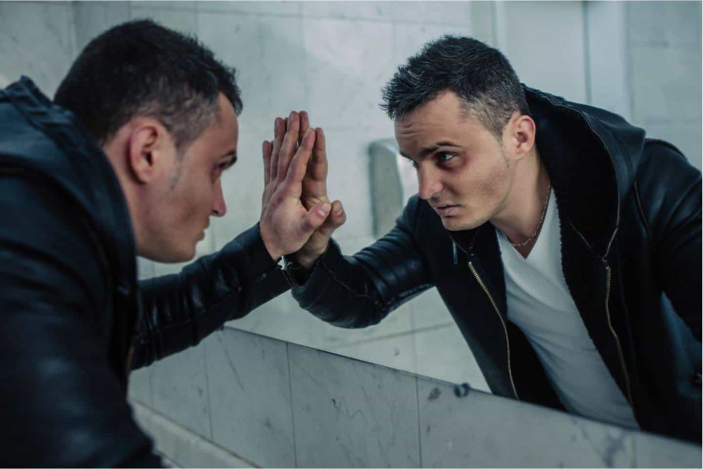 image of man looking at himself in the mirror representing the struggle of someone with substance abuse issues