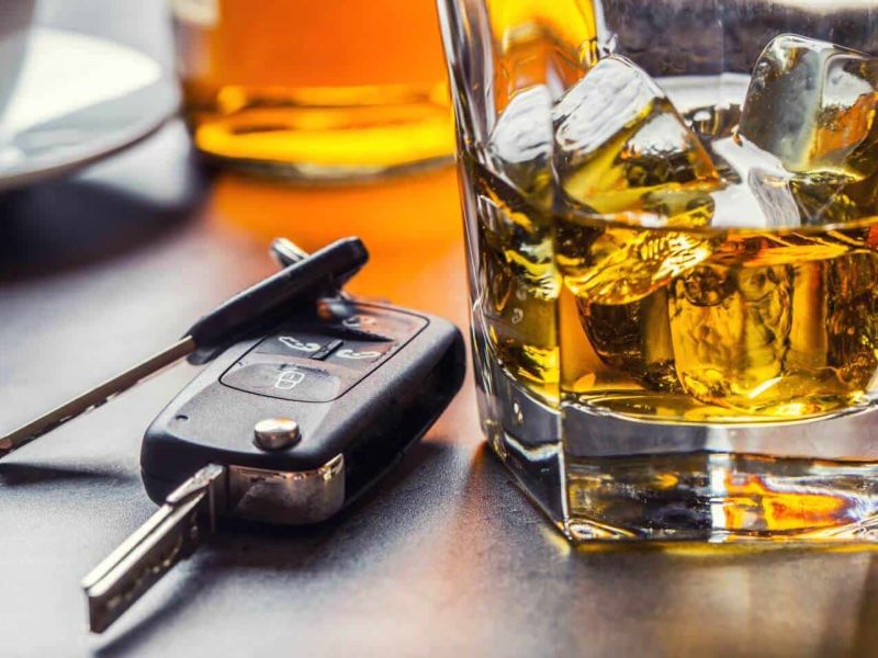 image of vehicle keys sitting next to a glass of alcohol representing the dangers of driving under the influence
